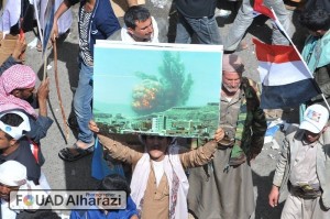 A Yemeni man holds a reminding picture of Vacuum bomb that hit Attan Mountain , heat and pressure weapons, on 20 April 2015 that killed 84 civilians , destroyed 700 houses and 800 causalities.