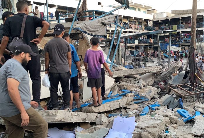 UN staff and Palestinians inspect the site after Israeli attack on a school of the United Nations Relief and Works Agency